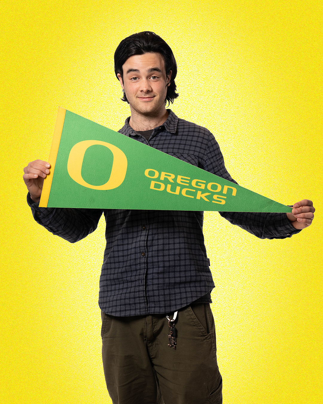 student declan zupo holding uofo pennant flag proudly