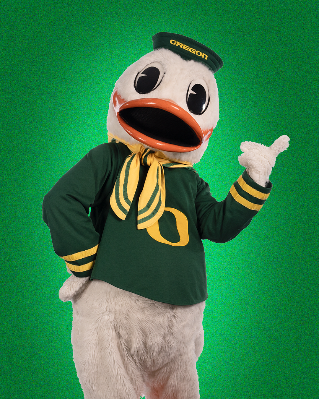 the oregon duck posing in front of uo green solid color background