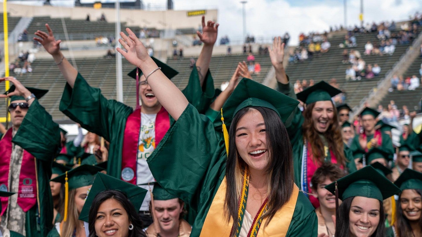 group of students cheering at commencement