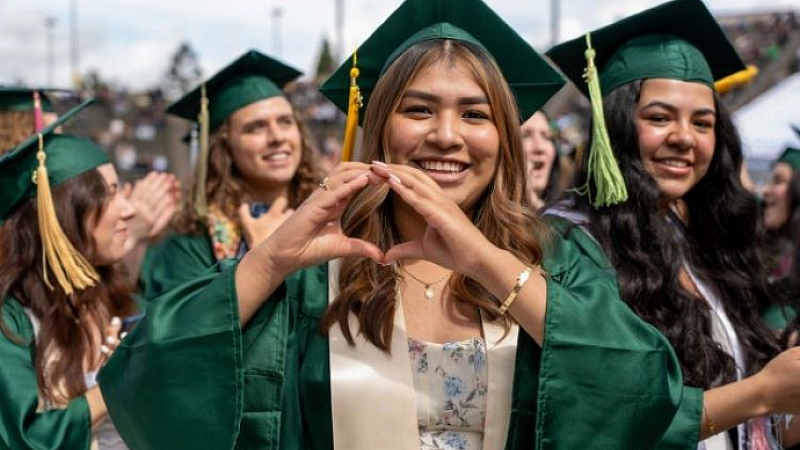 graduates celebrating at commencement throwing up an "o" symbol