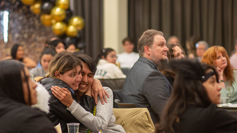 students embracing during a celebration dinner