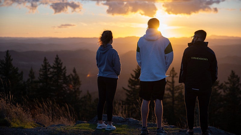 UO students gaze at the sunrise on top of Spencer Butte