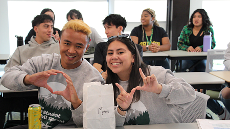 students smiling and posing throwing up the 'o' symbol representing oregon