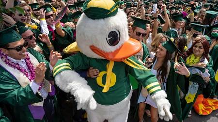 students celebrating commencement with the duck