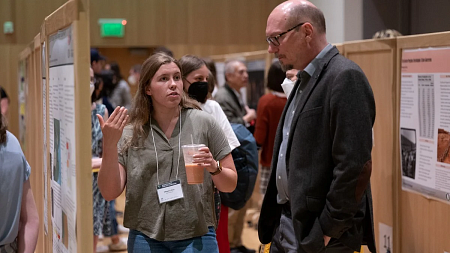 research symposium student talking to professor