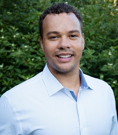 PathwayOregon alumni Willie Williams headshot outside in front of trees. He is wearing a blue long sleeve collared shirt