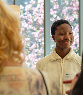 student participant of the undergradaute research symposium interacting with attendees.