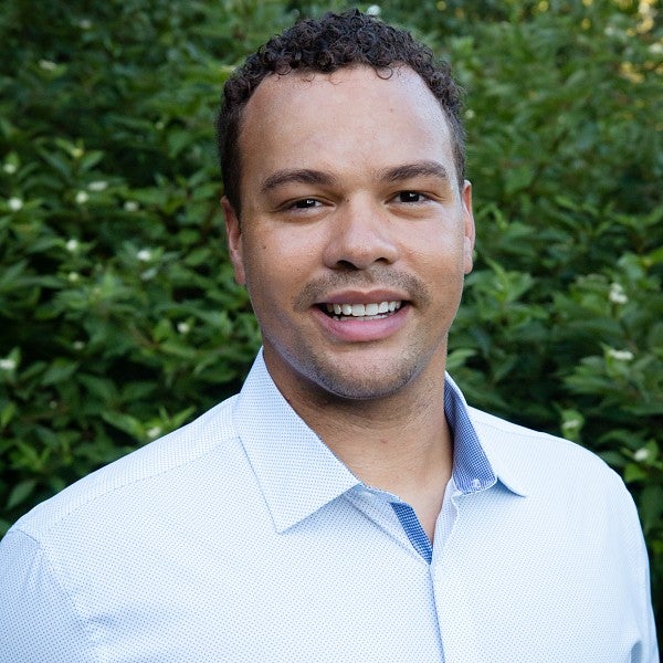 PathwayOregon alumni Willie Williams headshot outside in front of trees. He is wearing a blue long sleeve collared shirt