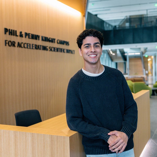 armaan hajarizadeh stands in front of phil and penny knight campus sign