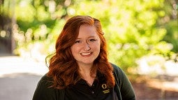 Jessica winders wearing a black University of Oregon polo shirt and smiling at the camera
